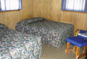The first bedroom in Cabin #12 has two double beds.
