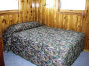 The first bedroom in Cabin #15 has a double bed.