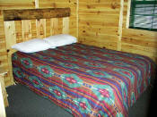 The Master Bedroom in Cabin #7 has a log headboard.